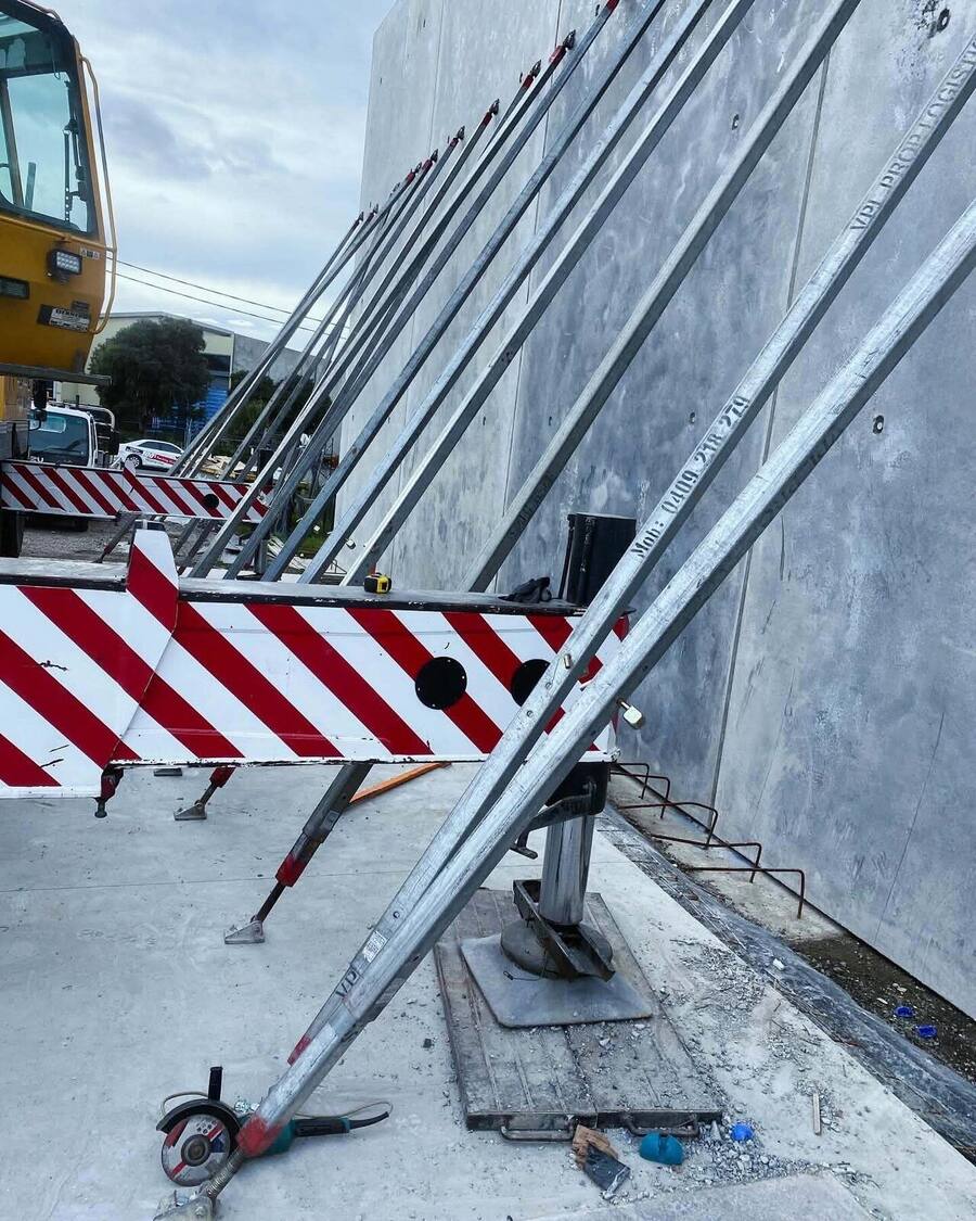 Props bracing a concrete tilt panel wall on a commercial site