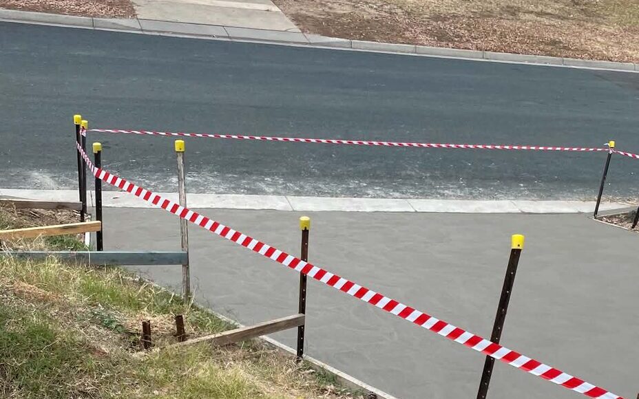 Freshly poured concrete crossover with barrier tape on a Victorian street